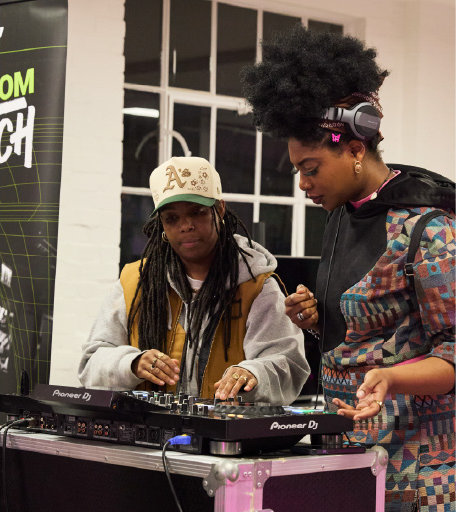 Two DJs mixing together at a workshop