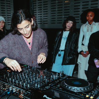 Attendee mixing on a Pioneer DJ setup while others watch at FOLD