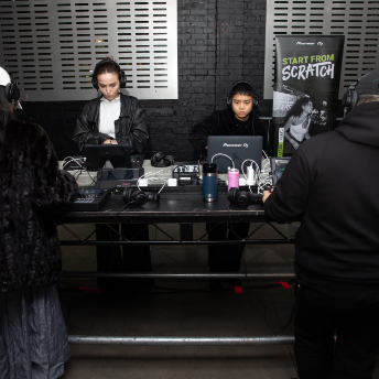Attendees setting up equipment beside a Start From Scratch banner at FOLD