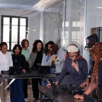 Attendee playing on the decks while the group watches at Pablo's T-Shirt Factory