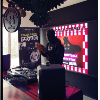 DJ playing beside the Start From Scratch banner in the concept store
