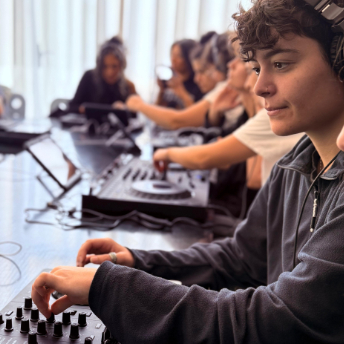Row of attendees practising on controllers in headphones
