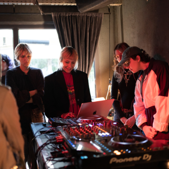 Attendees gathered around the Pioneer DJ setup by the window at Manasia HUB