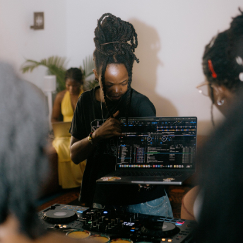 DJ cueing the next track on a laptop setup