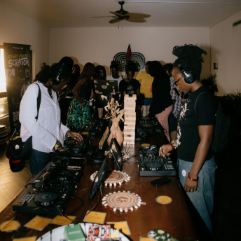 Guests gathered around the decks in a busy room at Homecoming Festival