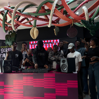Crowd watching a DJ set beneath the decorations at the Homecoming concept store