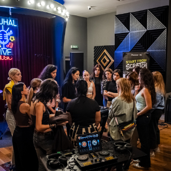 Group gathered around the decks beside the Start From Scratch banner at Zuhal