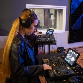 Attendee in headphones practising on a controller at Zuhal